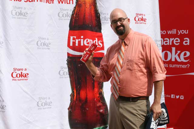 Joe McCartney poses with his two personalized Coca-Cola cans.