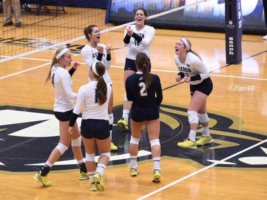 Volleyball squad celebrating as a team, after winning a set over BGSU.