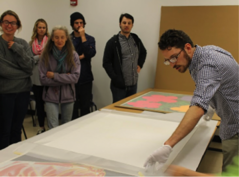 Graduate student, Ted Mallison, carefully unpacks the Warhol prints donated to the Myers School of Art