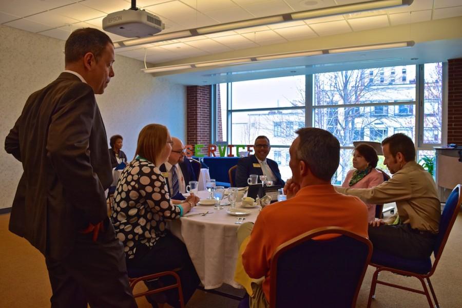 The faculty who attended the luncheon socialize on the topic of the day before the food is served. 