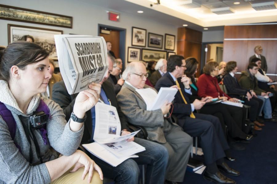Ashley Bair silently protests by holding up the Akron Beacon Journal 