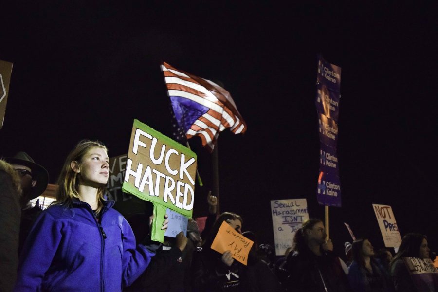 Demonstrators hold signs as they march down W. Market Street during the protest in Highland Square on Tuesday night.