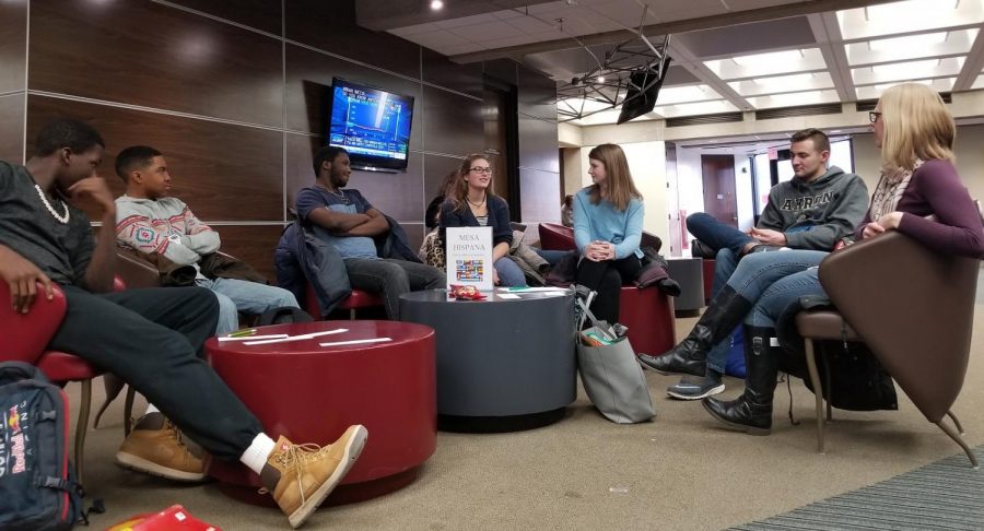 Instructor Cortney Benjamin (right), The University of Akron students Bryce Chekann, Rebecca Hohman, Kelsey Joyce, Gregory Holmes, and others (right to left) talking about the Olympics, food preferences and favorite activities during Mesa Hispana, Feb. 13, 2018.