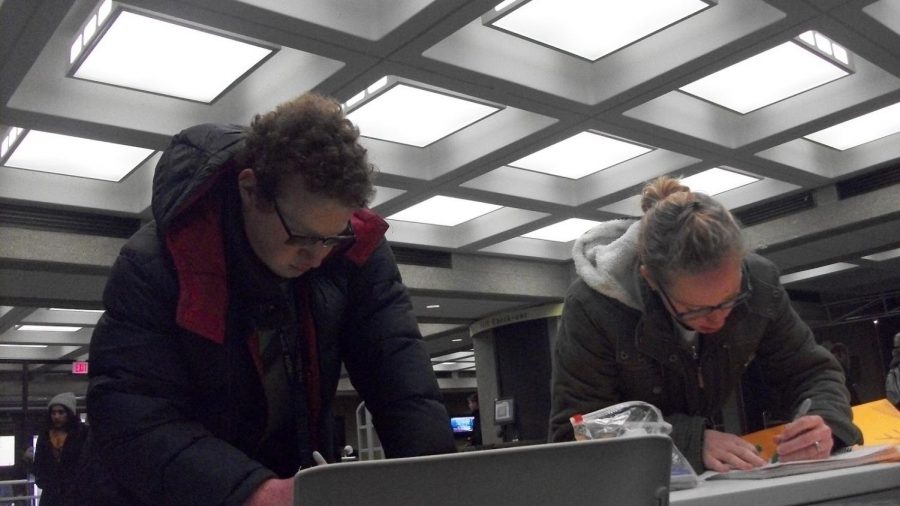 University of Akron students Ben Roter and Lily Kuzmik create anti-gun violence posters in Bierce before the Walkout protest.