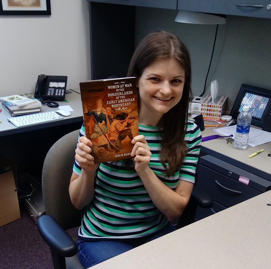 Dr. Martino with her book, Women at War in the Borderlands of the Early American Northeast, in her office in the Buchtel College of Arts and Sciences.