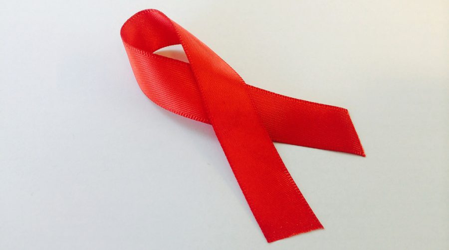 According to worldaidsday.org, the red awareness ribbon was created in 1991 by twelve artists in New York. (Image via NIAID on Flickr)