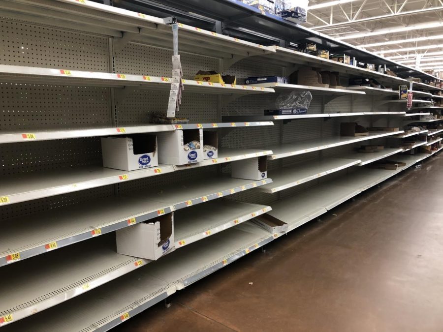 Aisles that normally house non-perishable foods and other supplies are nearly empty after shoppers engage in “panic buying” due to COVID-19.