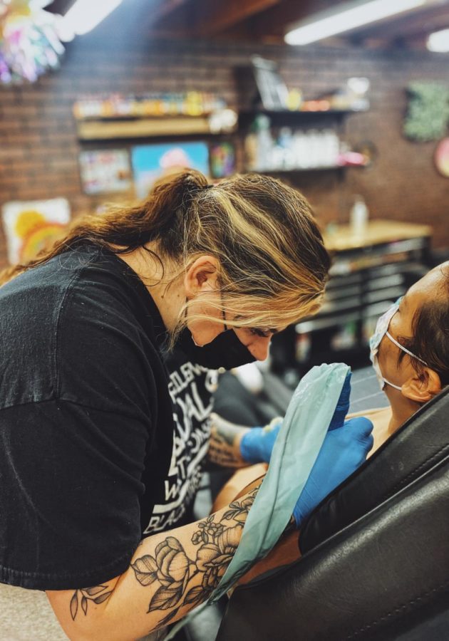 Artist Sadie Winter, tattooing a client