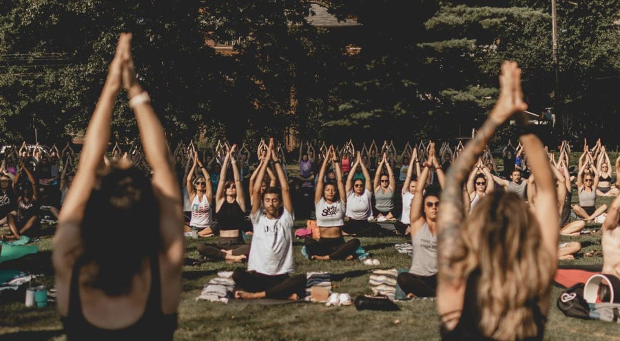 Owners of Yoga Squared, Nicole Woodford-Shell (left) and Kate Woodford Shell (right), lead a free community yoga class to kickoff Highland Square’s
annual Porchrokr Music x Arts Festival.