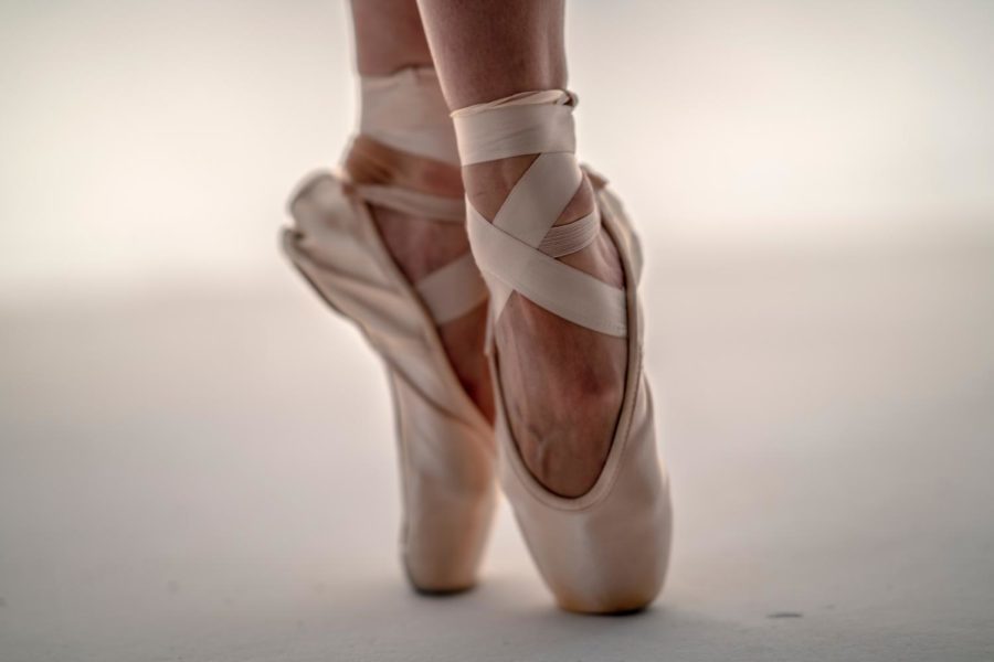 Ballet dancer twirls in pointe shoes.