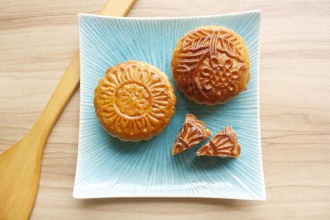 Photo of Chinese Moon Cakes on a blue plate with a spoon.